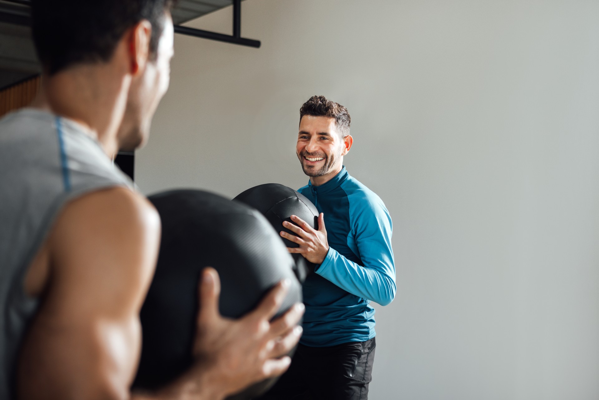 Smiling personal trainer in fitness class with medicine ball